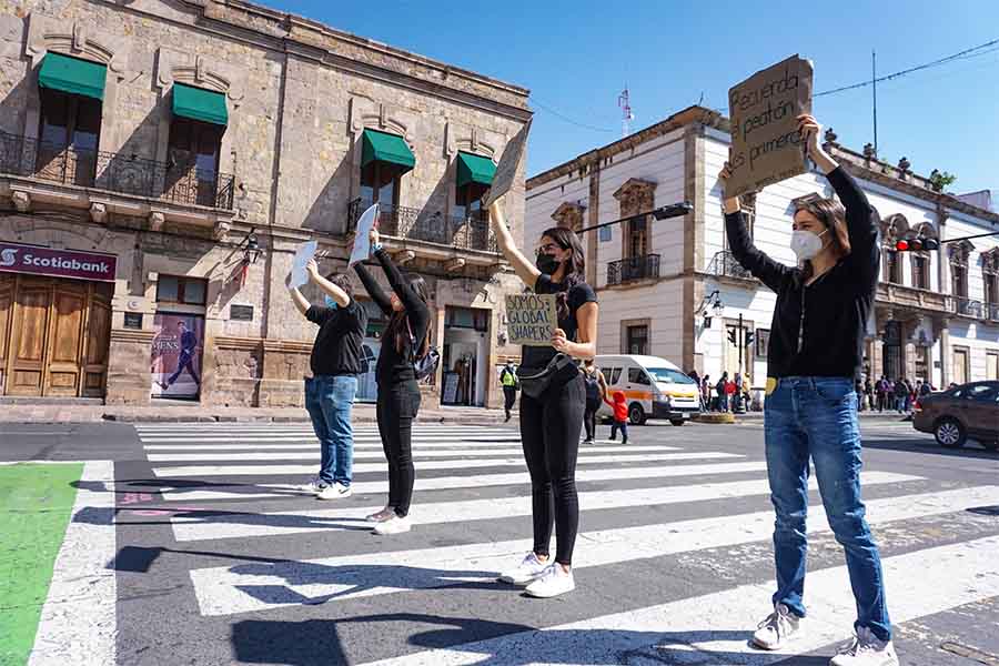 Activistas urbanos mostrando sus carteles en un cruce peatonal del centro histórico de Morelia