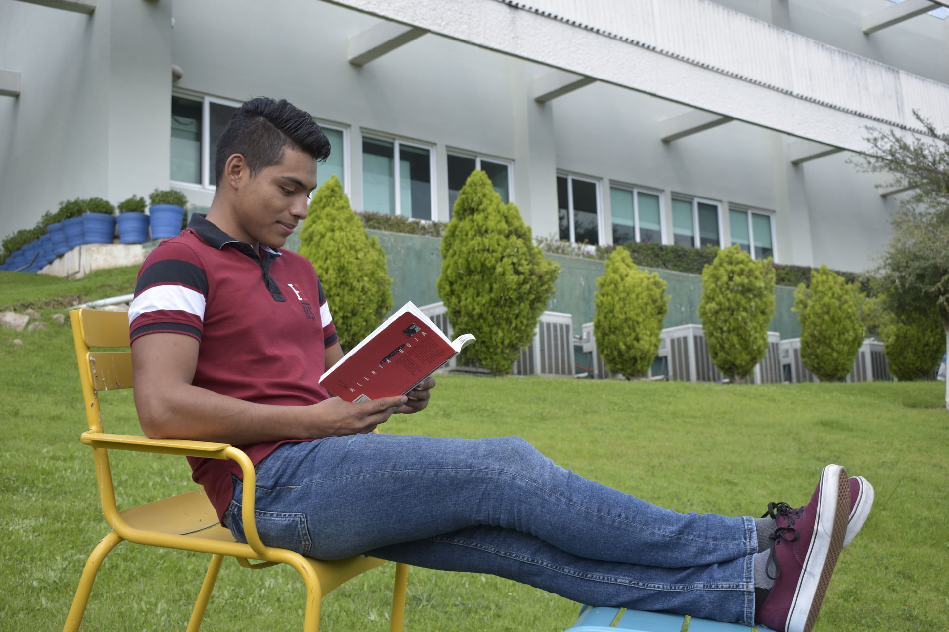 Alumno de Morelia leyendo en las áreas verdes del campus