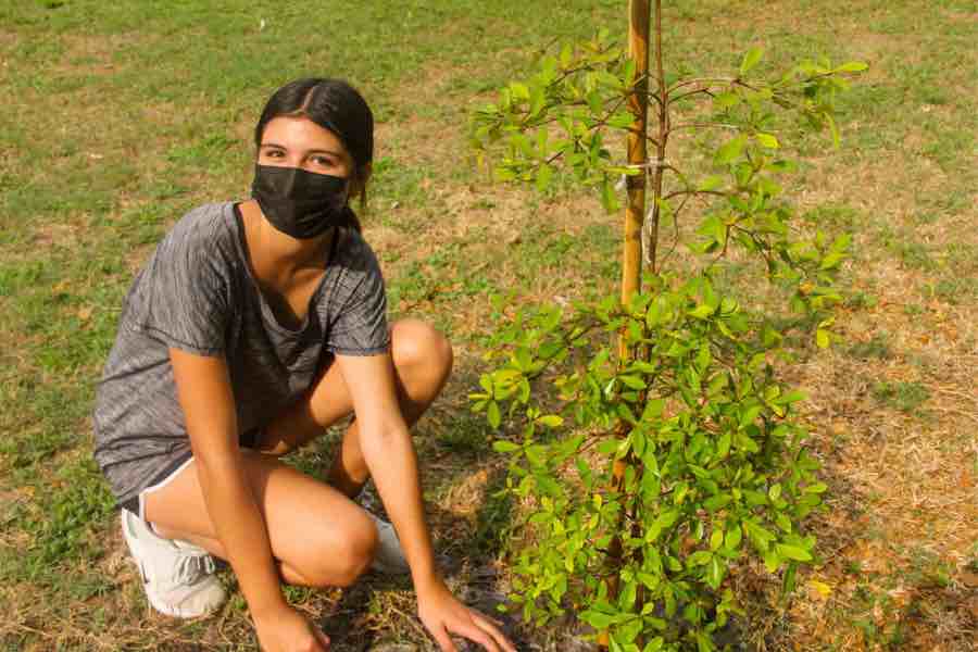 Alumna plantando árboles en el campus