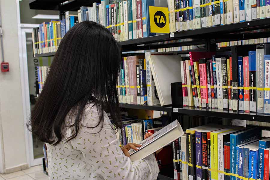 Rosas en la bibloteca viendo los libros
