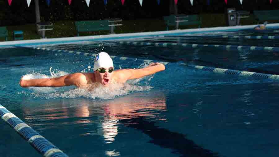 Nadador saliendo del agua mientras bracea