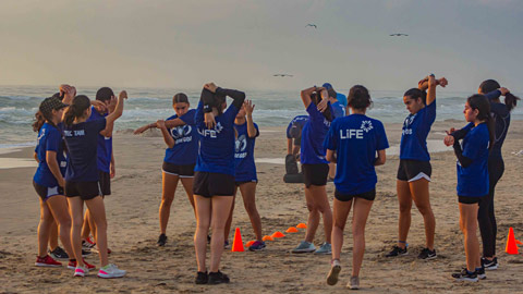 equipo de futbol femenil entrenando en la playa