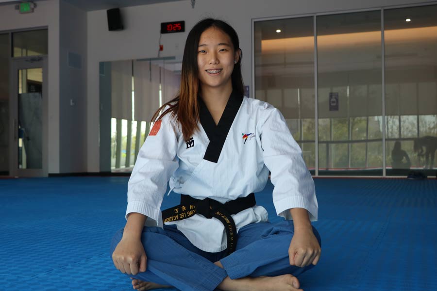 Cecilia Lee sentada en el área de taekwondo del Wellness Center.