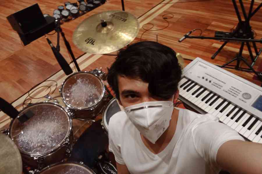 Juan Pablo tomándose una selfie frente una batería y un teclado
