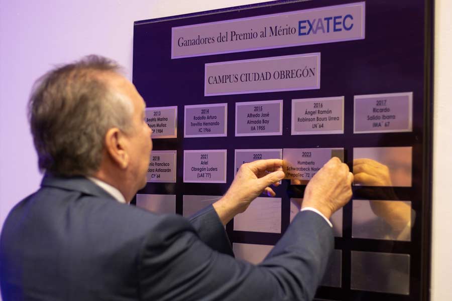 Momento en el que el galardonado coloca la placa con su nombre entre los ganadores al Mérito EXATEC de Obregón