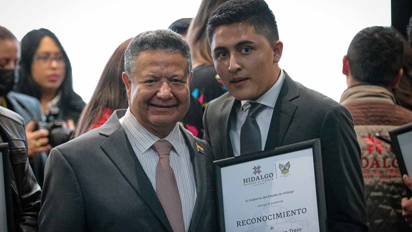 Yovanni Guerrero posa con su reconocimiento y con el gobernador de Hidalgo, Julio Menchaca
