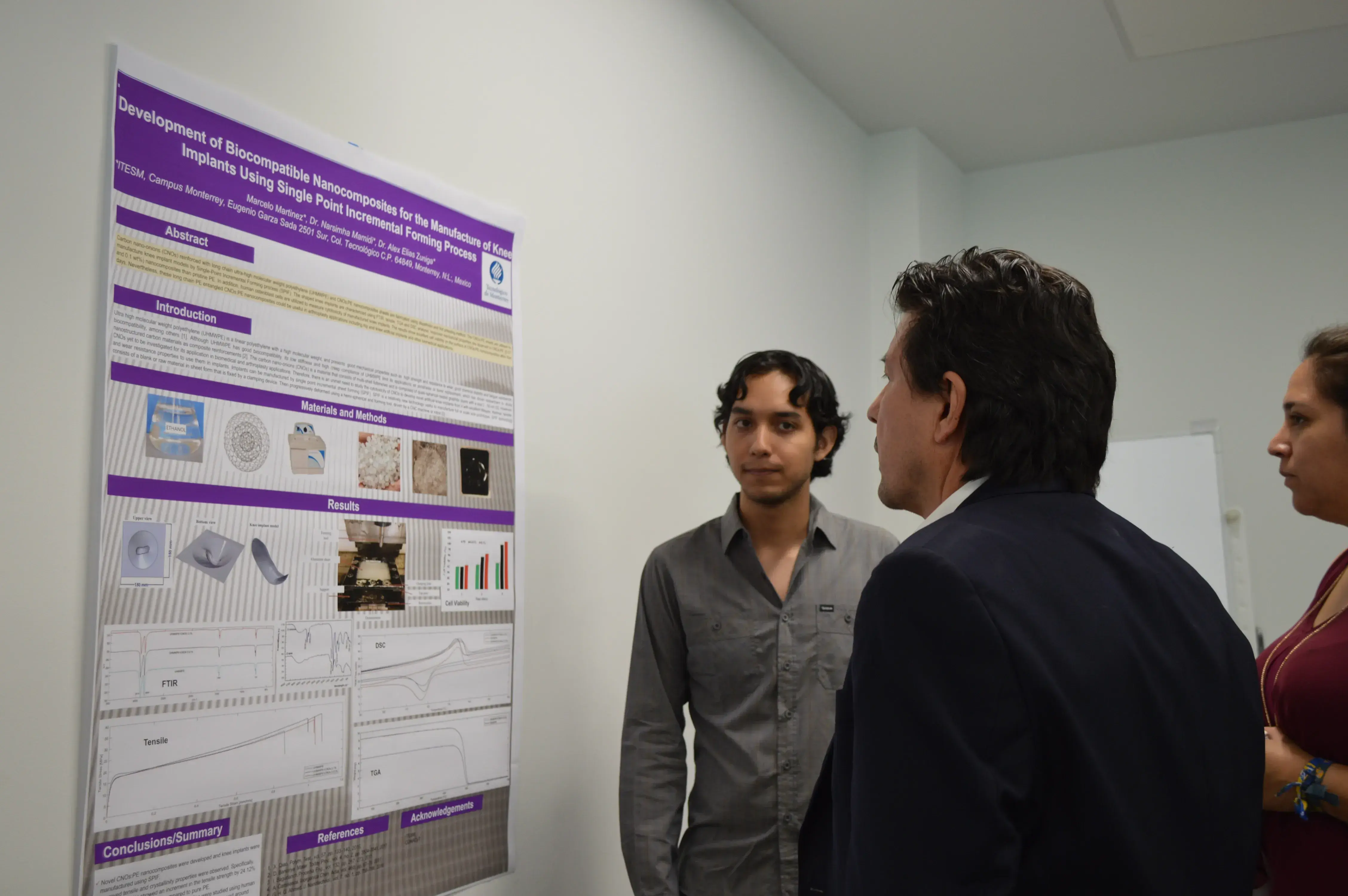 Marcelo Martínez presentando su poster al profesor Rogelio Soto y Adriana Canseco
