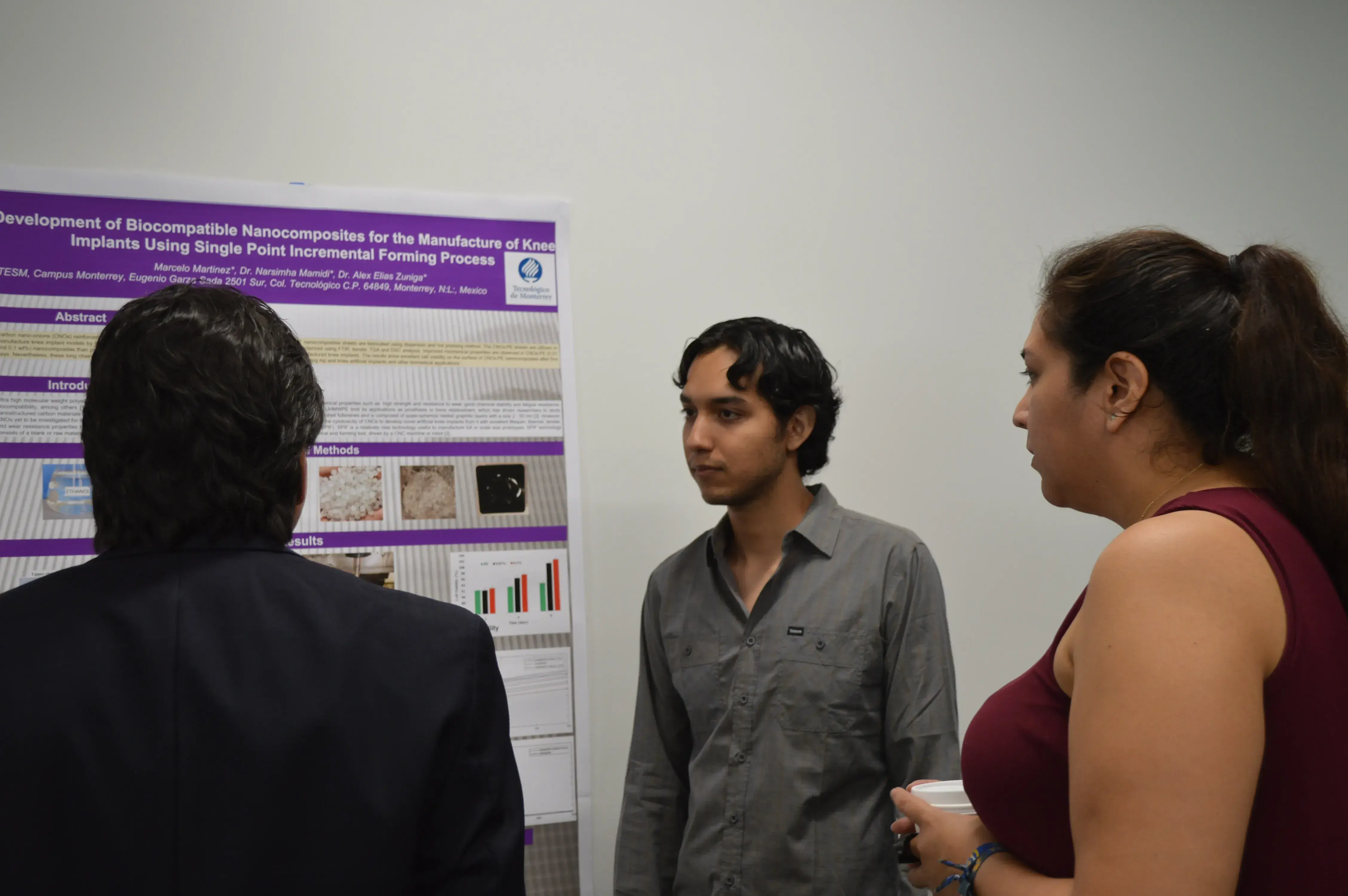 Marcelo Martínez presentando su poster al profesor Rogelio Soto y Adriana Canseco
