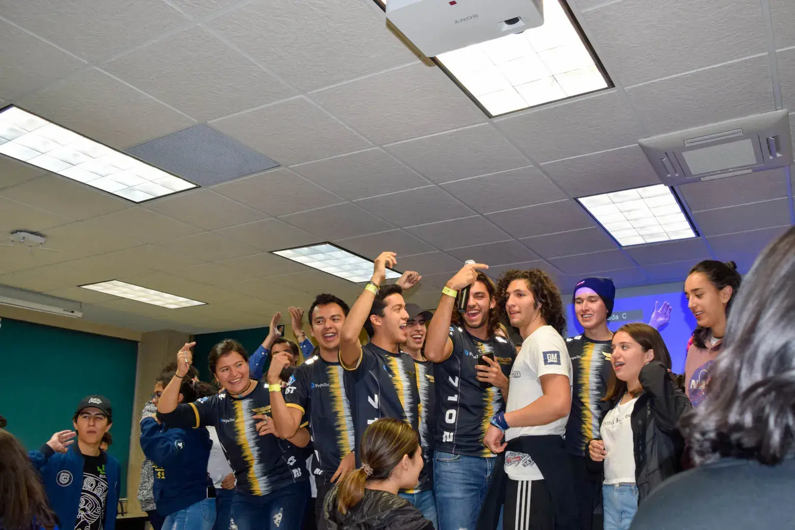 Miembros de distintos equipos cantando y celebrando.