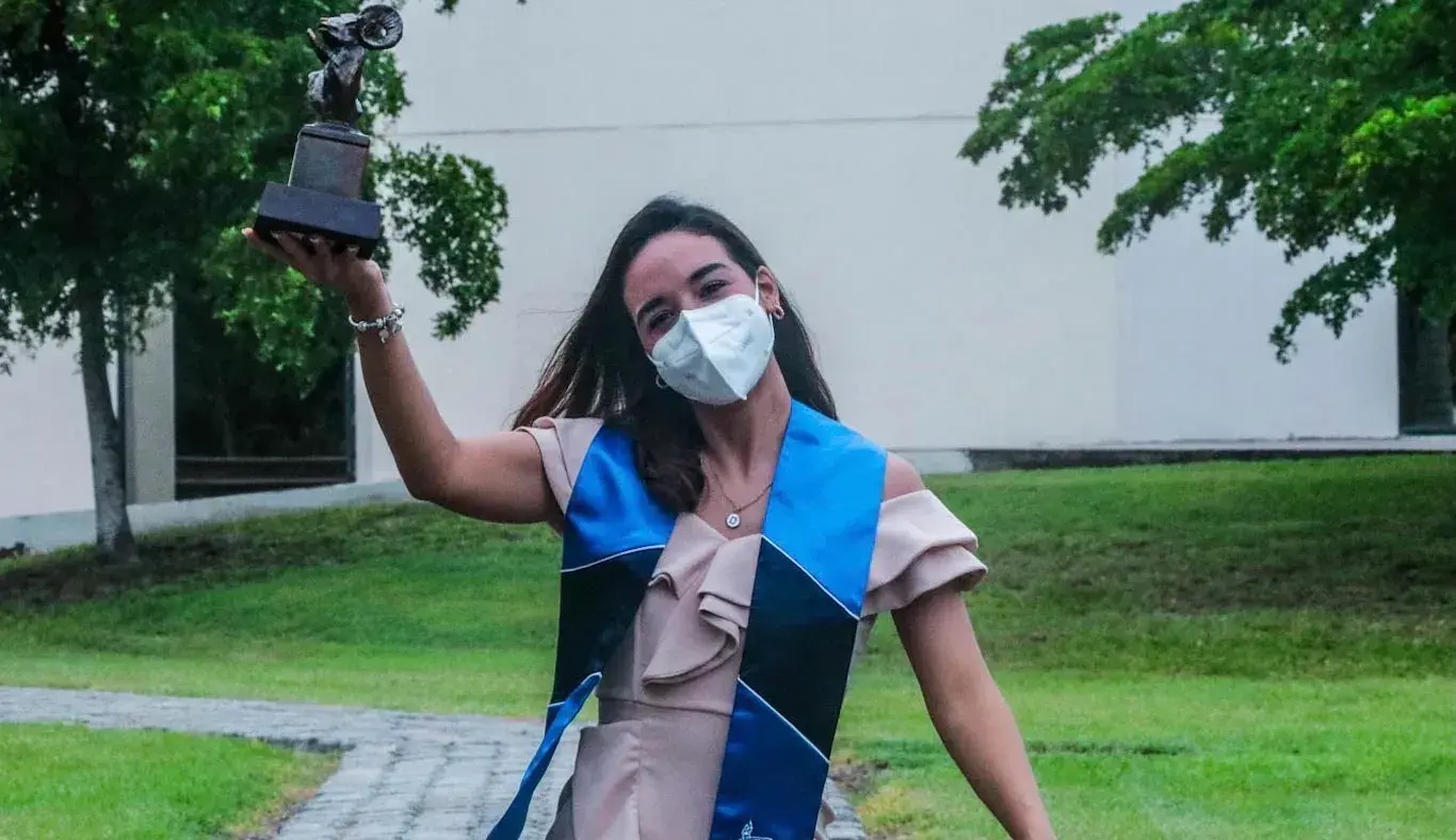 Alumna festejando con su borrego de oro 