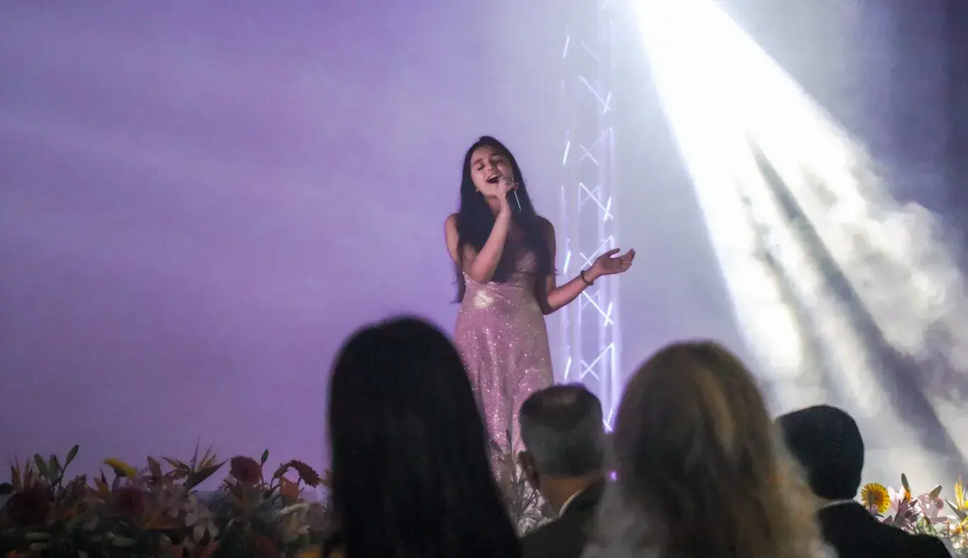 Alumna cantando en evento de graduación