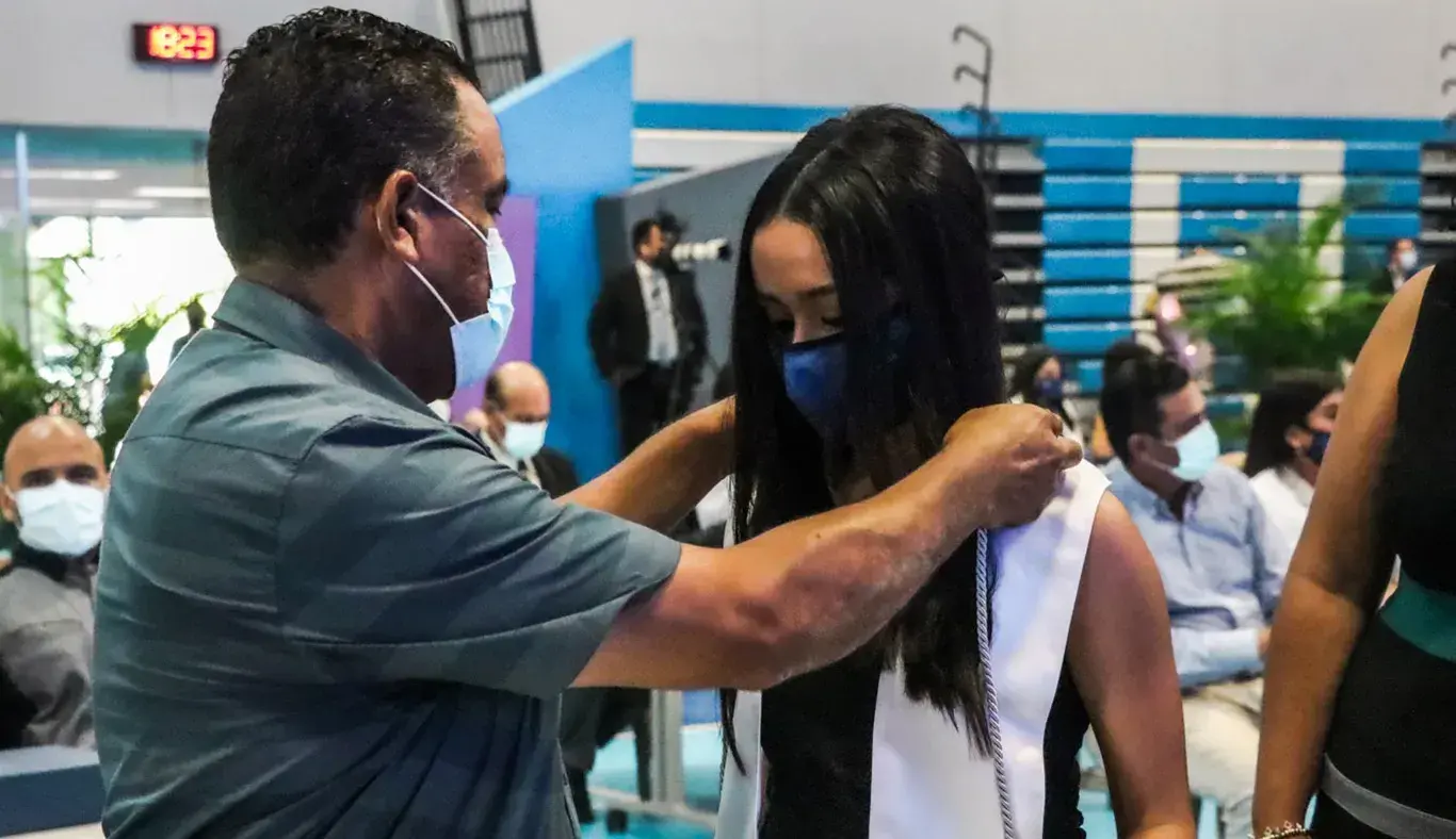 Papá colocando estola a su hija graduada