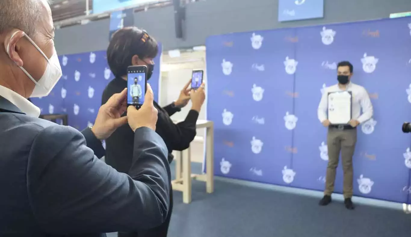 Un papá y una mamá fotografiaron a su hijo tras firmar su título.