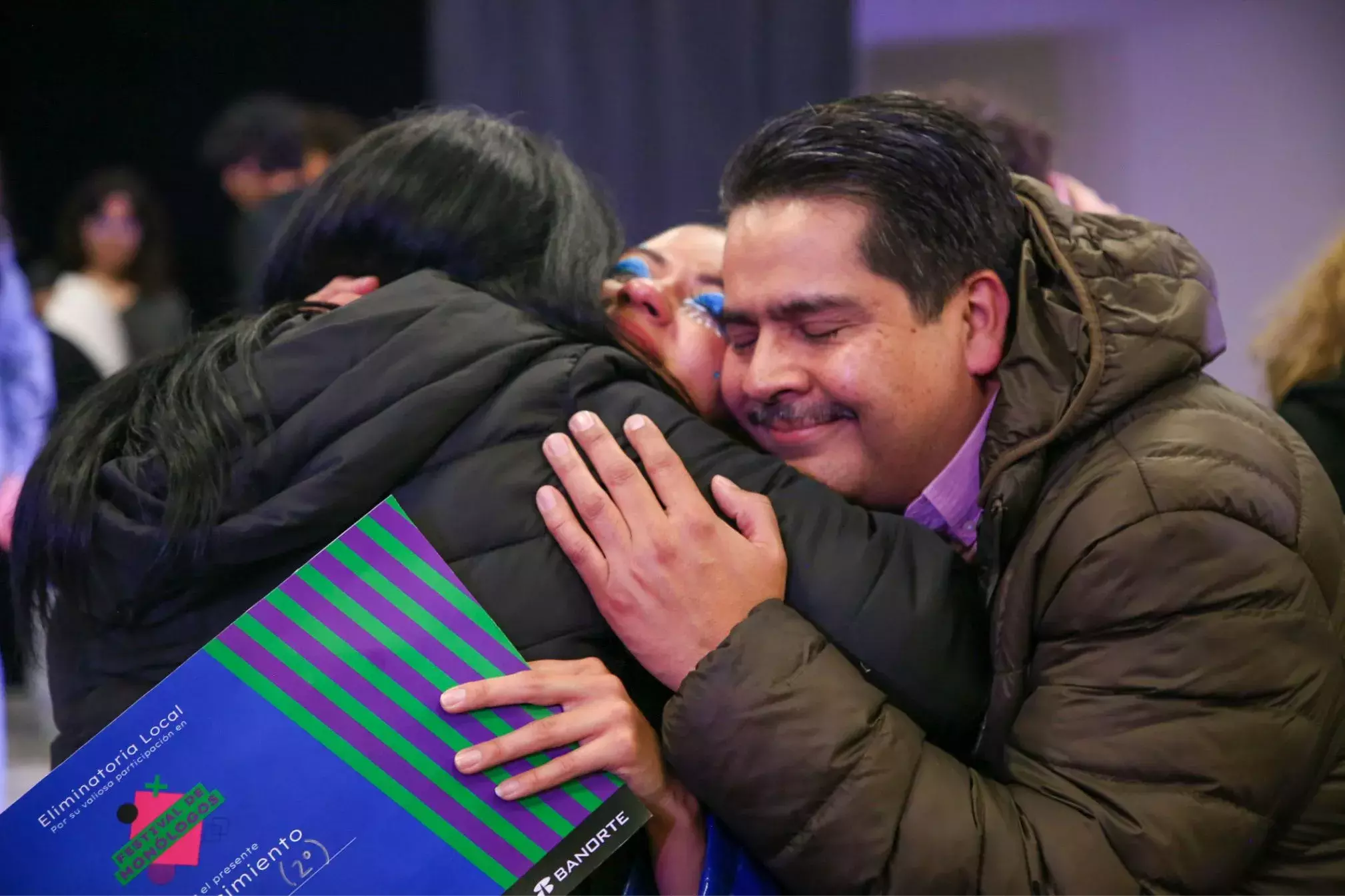 Padres de familia abrazando a su hija