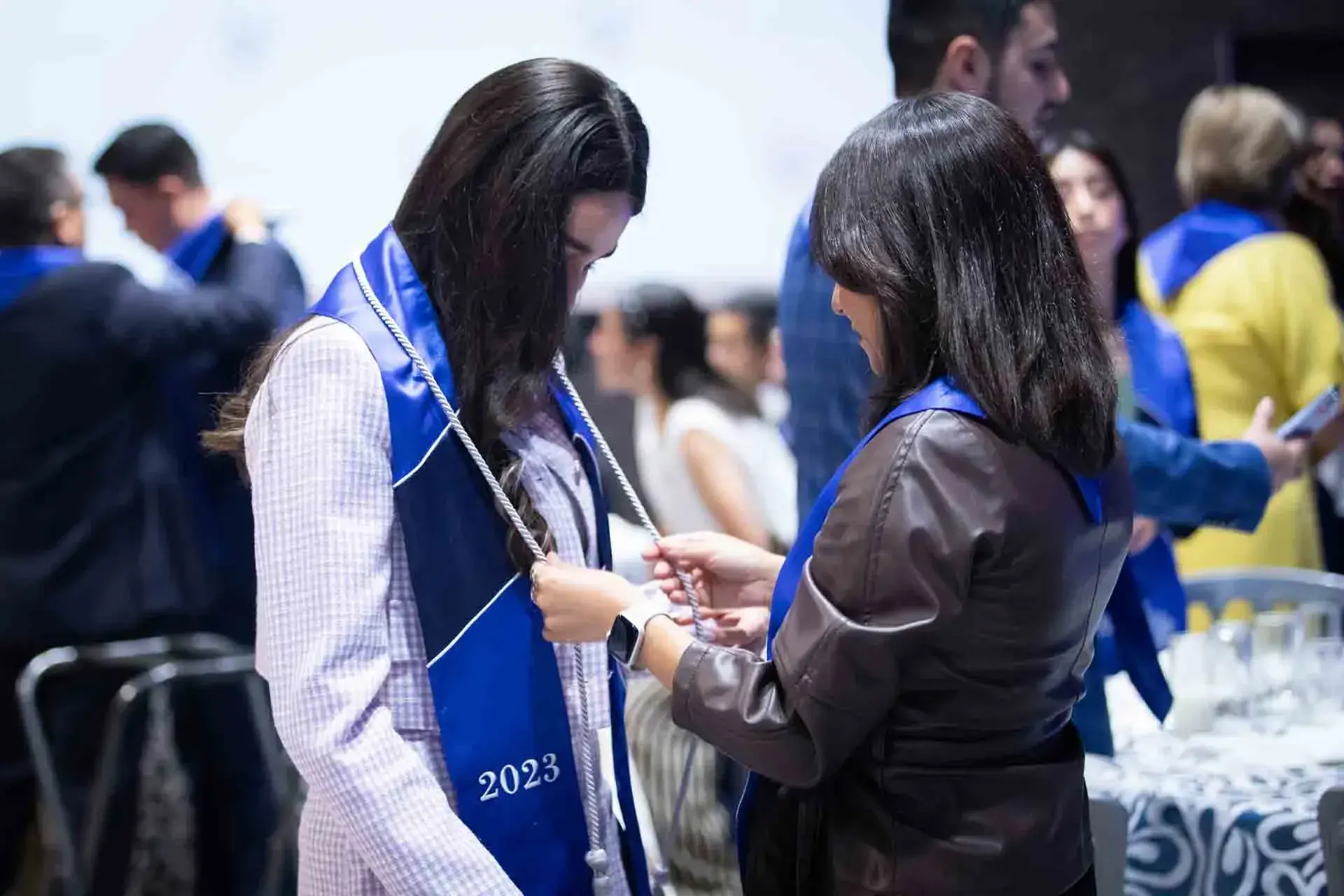 Maestra poniendo estola a graduada.