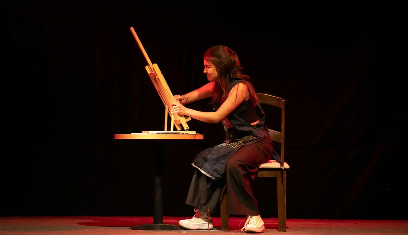 Estudiante del representativo de teatro pintando un cuadro agresivamente en su monólogo