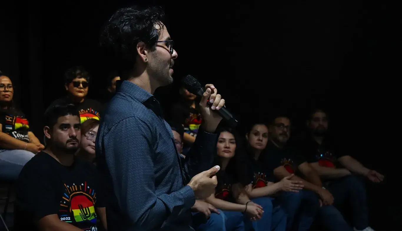 Hombre hablando con un micrófono en mano. 