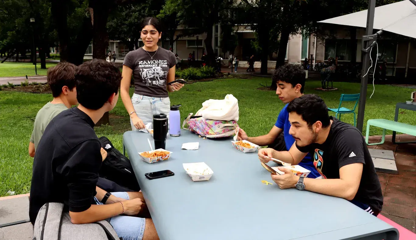 Alumnos sentados comiendo Chilaquiles Tec.