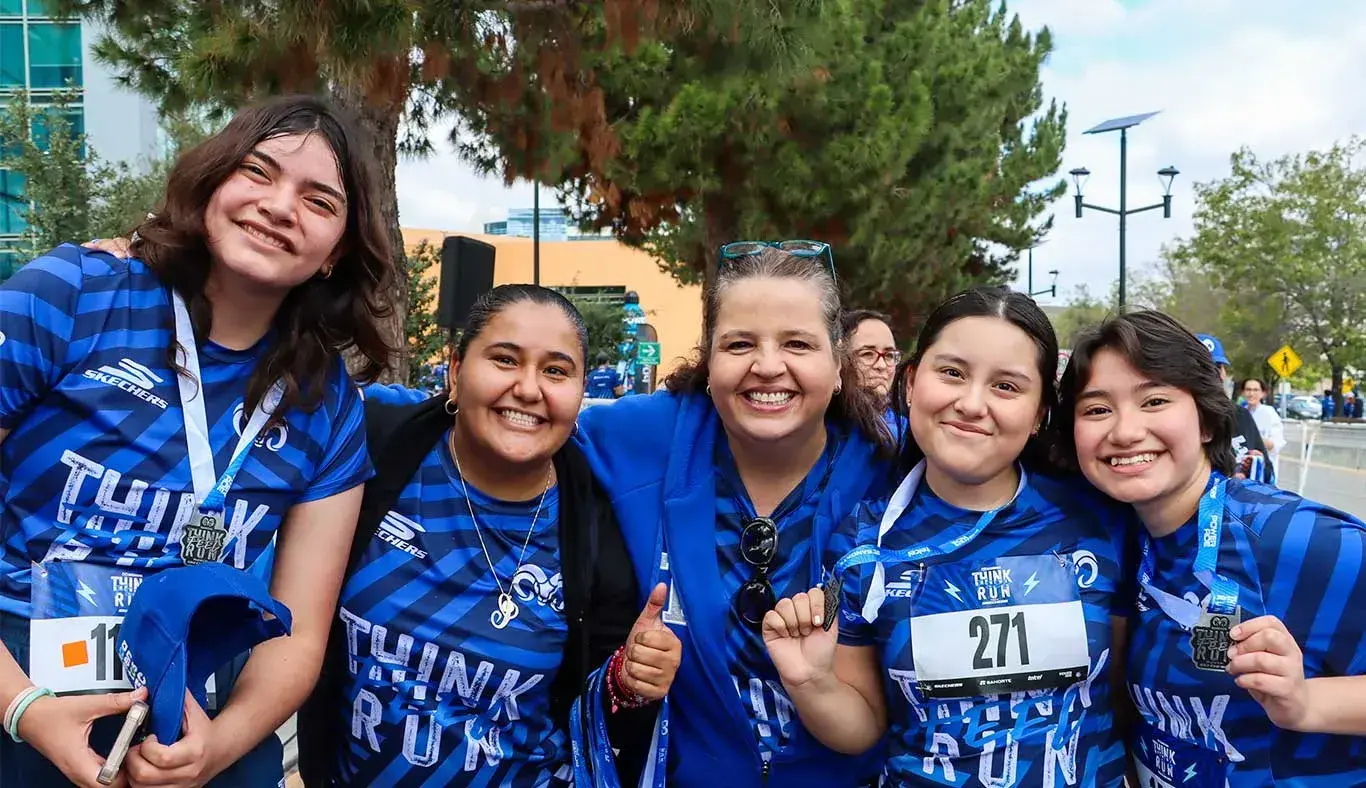 Colaboradores y estudiantes sonriendo en la meta 