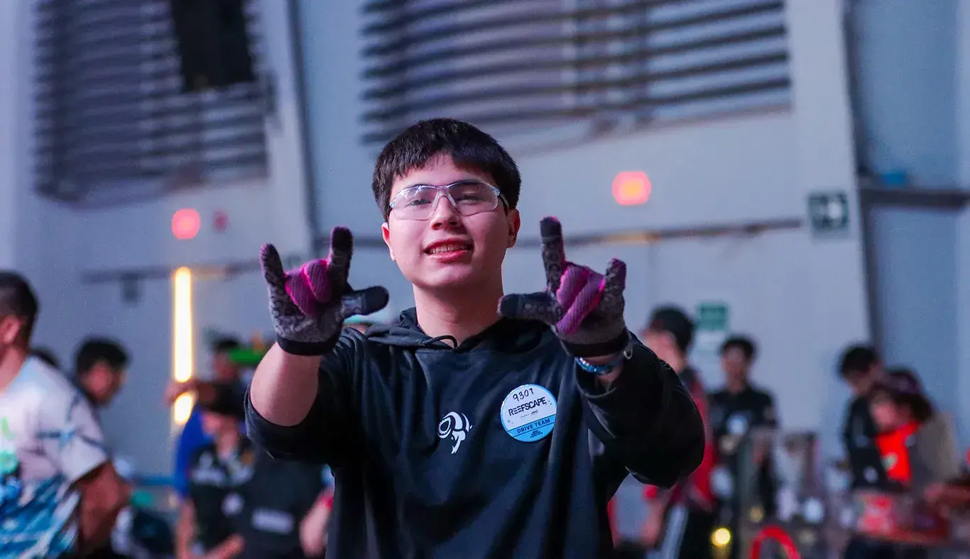 Estudiante posa y hace señal de rock a la cámara en FIRST Regional Laguna