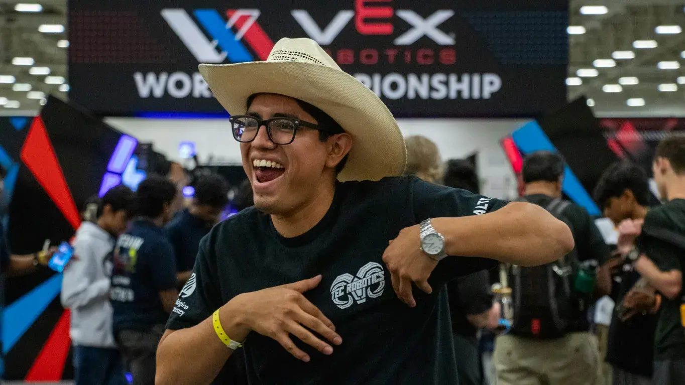 Alumno con sombrero sonriendo. 