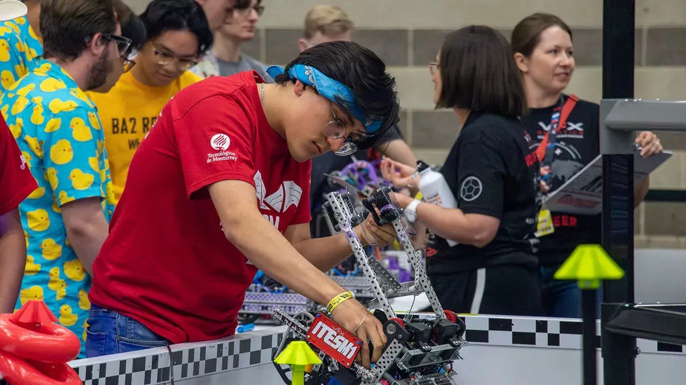 Alumno reparando un robot.