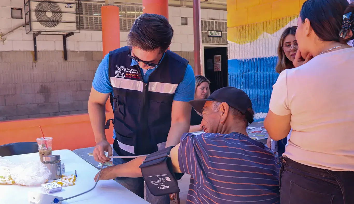 Personal de Secretaría de la Salud le toma la presión a un hombre.