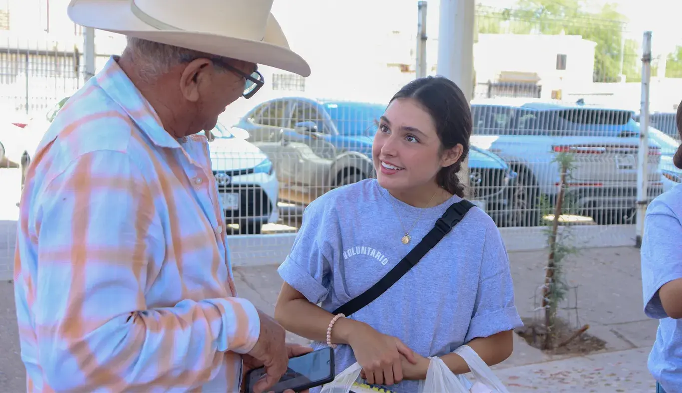 Mujer joven platicando con hombre mayor.