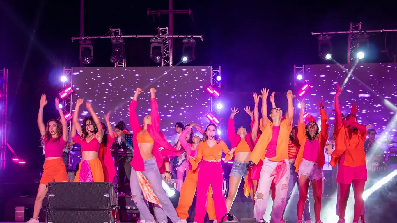 Alumnos cantando y bailando en musical.