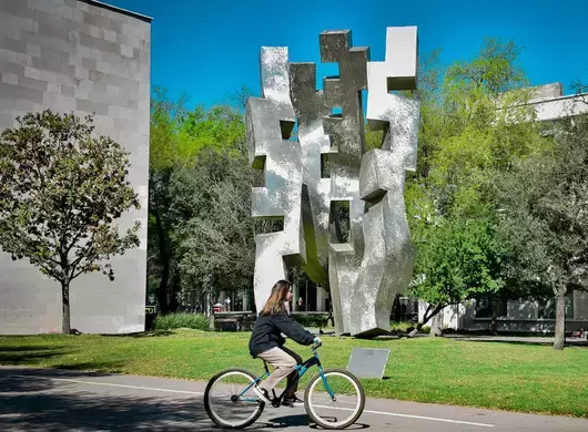 Estudiante del Tec, campus Monterrey, transportándose en bicicleta dentro del campus