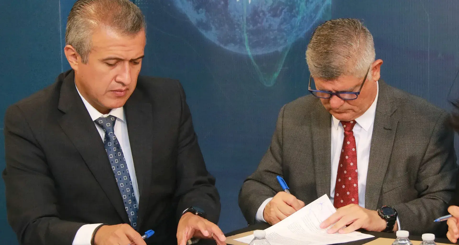 Profesores firmando convenio
