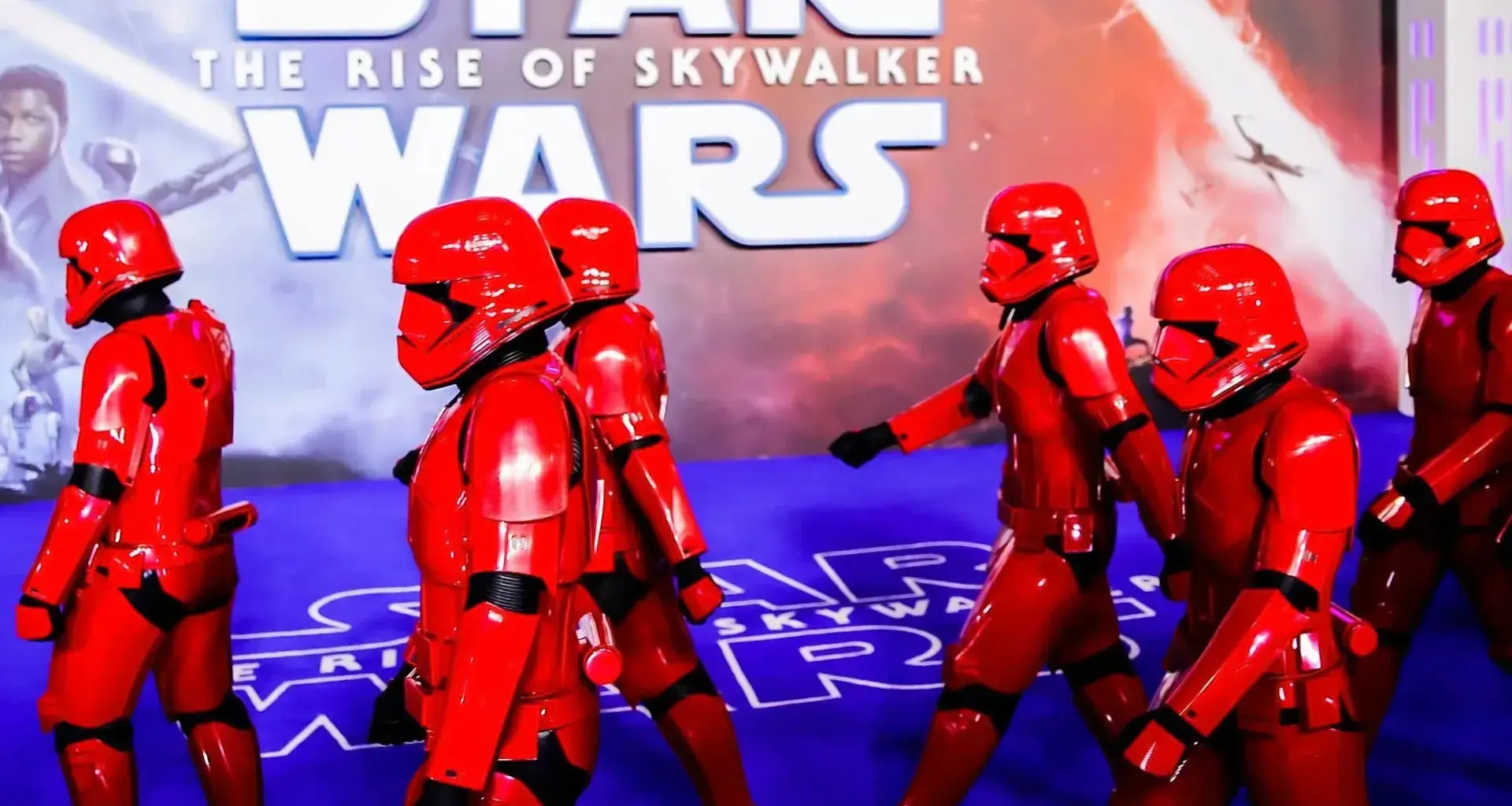 Stormtroopers desfilando con poster de starwars al fondo