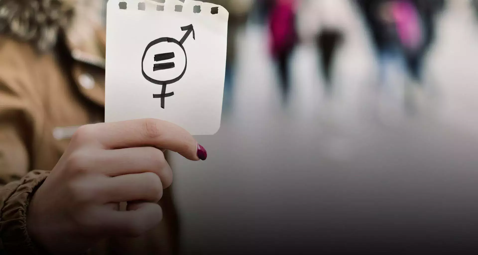 Mujer sosteniendo una hoja con signo de igualdad de género