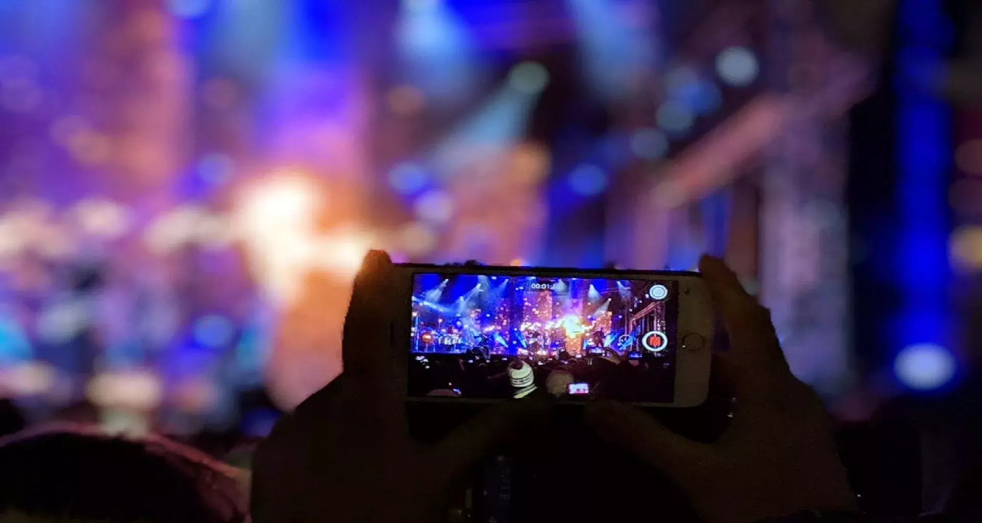 Persona grabando video de concierto en su celular
