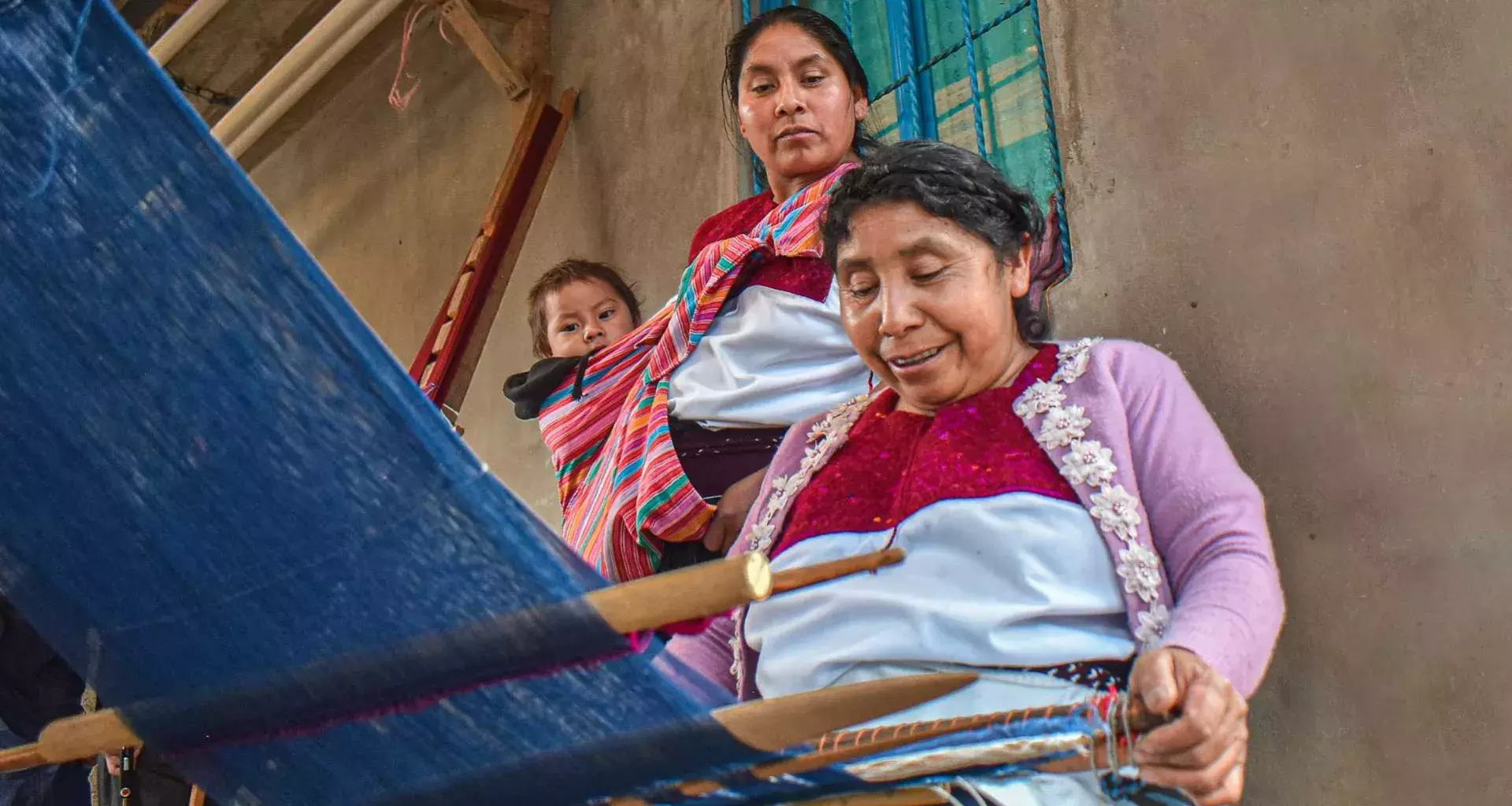 Familia de tejedoras de Chiapas en el proceso de telar de cintura maya
