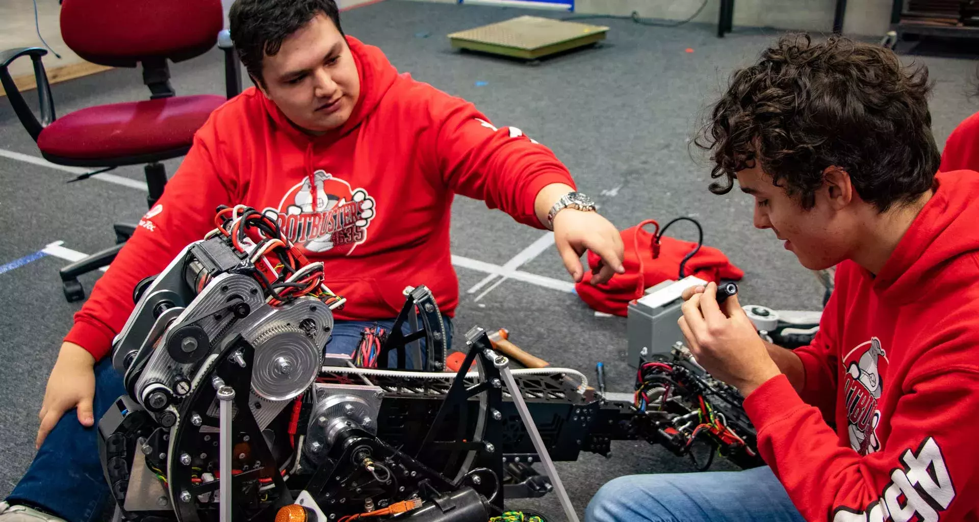 El coach Francisco Rosas ayudando a un estudiante con el robot.