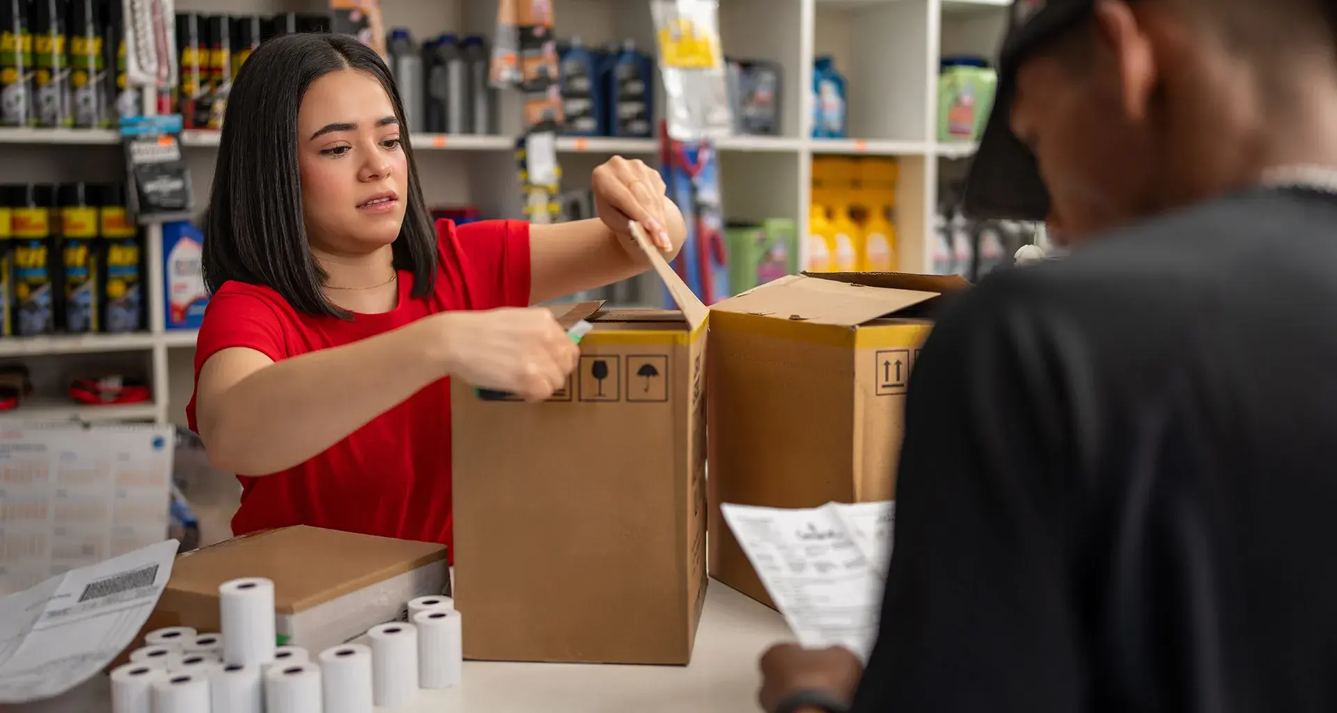Joven despachando mercancía en tienda.