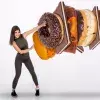 Imagen conceptual de chica luchando contra unas donas gigantes y chocolates de comida