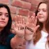 Alumnas mostrando frase escrita en sus manos