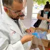 doctor abre paquete de proyecto nabawa de egresados del Tec con caretas médicas para combatir covid19.