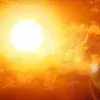 Fotografía del sol reflejando sus rayos en el cielo con tonalidades rojizas/naranjas por altas temperaturas.