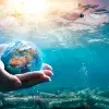Image of the ocean contaminated with the world held in between two hands
