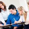 Profesora interactuando con un grupo de 4 alumnos