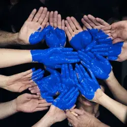 Manos juntas con pintura azul formando un corazón