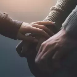 Persona tomando de la mano a otra persona