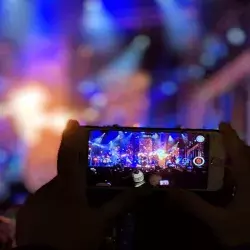 Persona grabando video de concierto en su celular
