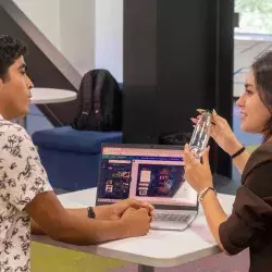 carlos y alicia explicando su proyecto con una computadora