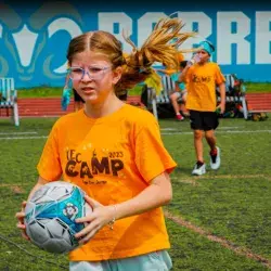 Participante del campamento de verano jugando fútbol