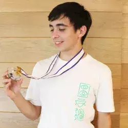 Eric Ransom sosteniendo su medalla de plata obtenida en la Olimpiada Internacional de Matemáticas.