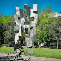 Estudiante del Tec, campus Monterrey, transportándose en bicicleta dentro del campus